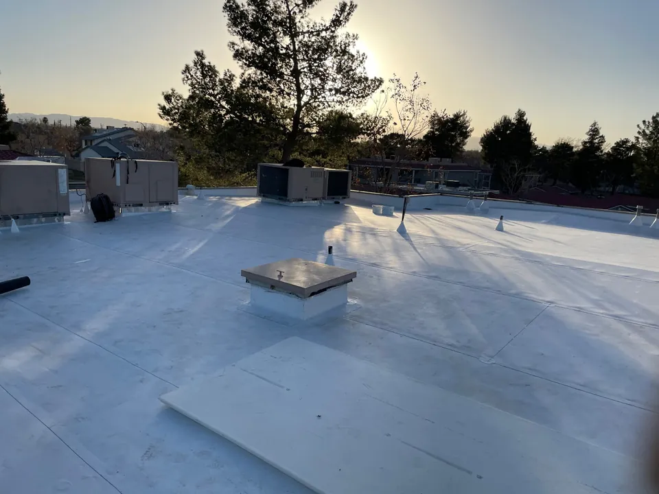 New white flat roof with a roof hatch, vents and AC units