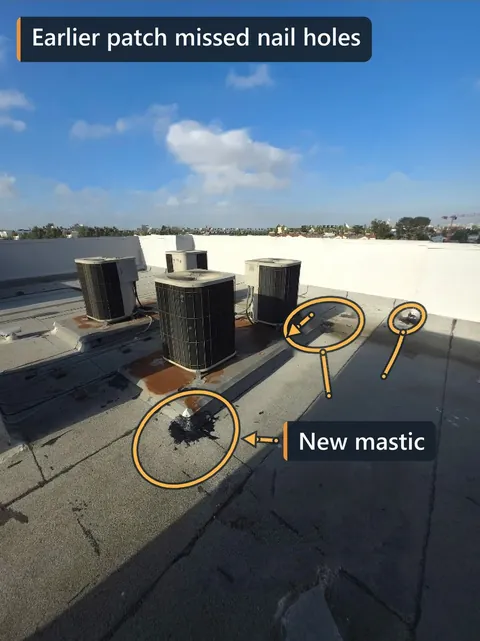 Flat rooftop with three AC units; new mastic from an earlier patch and the nail holes it missed are circled