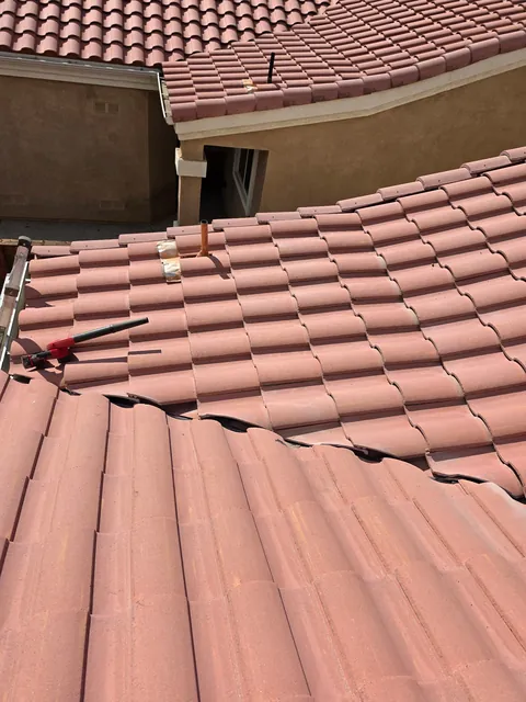 Tile roof on a stucco home with a course of tiles lifted for repair